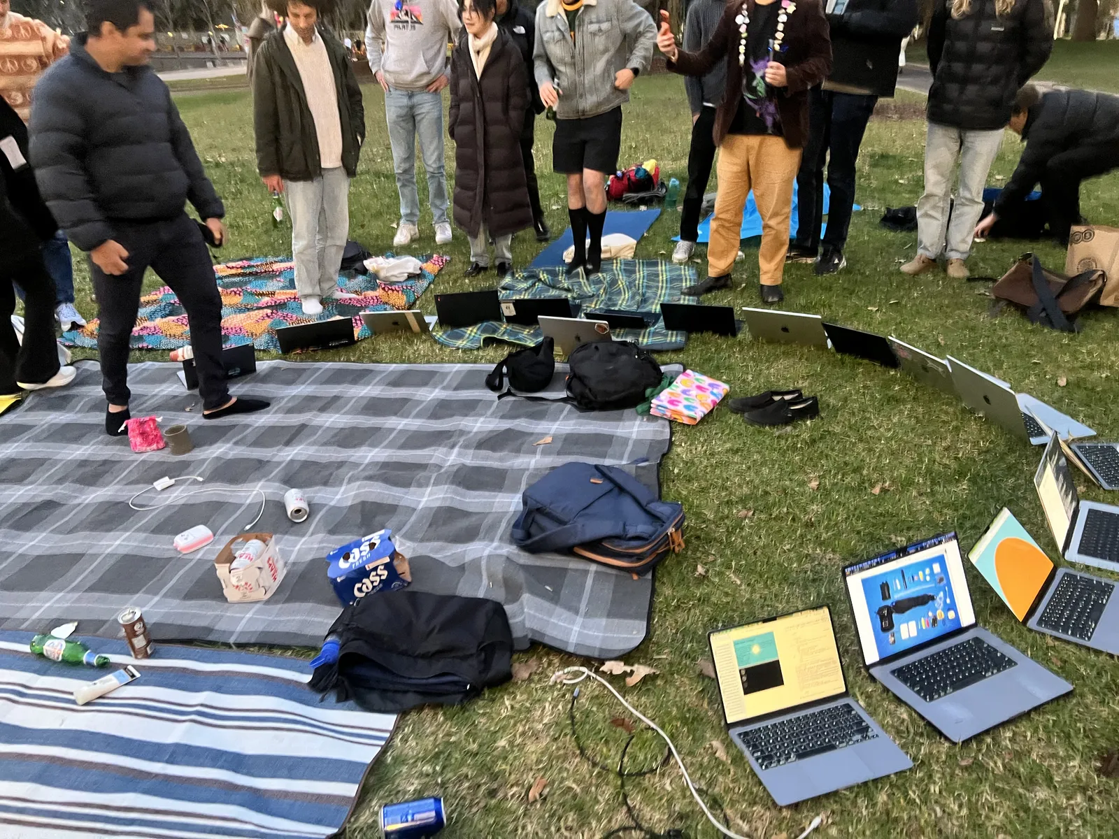 Circle of open laptops on blankets